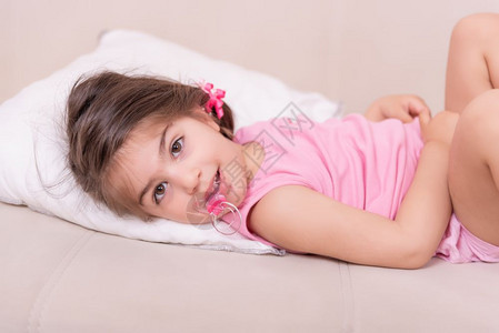 可爱女孩的肖像躺在床上嘴里有奶选择的焦点和很小田地深度图片