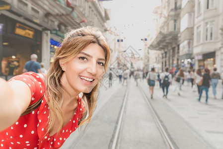 穿着红裙子的美女在Istiklal街自拍这是土耳其伊斯坦布尔Beyoglu区一个受欢迎的地方图片