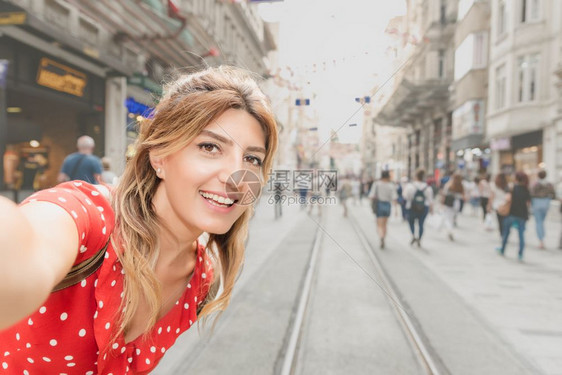 穿着红裙子的美女在Istiklal街自拍这是土耳其伊斯坦布尔Beyoglu区一个受欢迎的地方图片