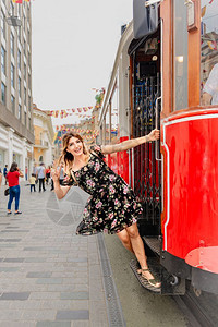 美丽的女人挂在土耳其伊斯坦布尔Istiklal街的Bestiklal街的怀旧电车上图片