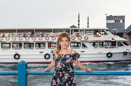 在土耳其伊斯坦布尔的加拉塔桥新清真寺和埃米诺努镇的土耳其伊斯坦堡美丽的女肖像美丽女乘渡轮往返于亚洲和欧之间图片