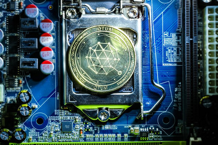 计算机母板处理器上金色Qtum加密硬币的顶端视图Bitcoin采矿场计算机设备概念图片