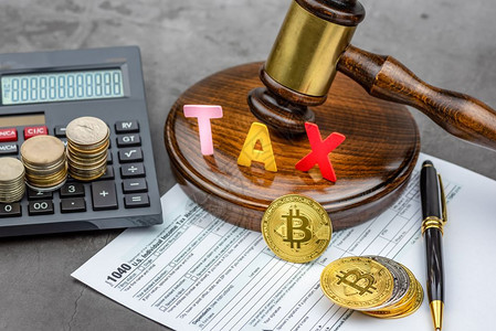 Bitcoin加密货币前方的视图手架前面有TAX单词和计算器Tax支付概念图片