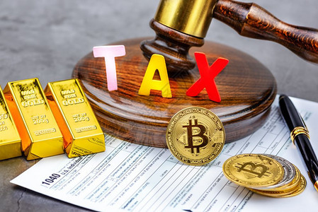 Bitcoin加密货币前方的视图在手架前使用TAX单词计算器和金砖Tax支付概念图片