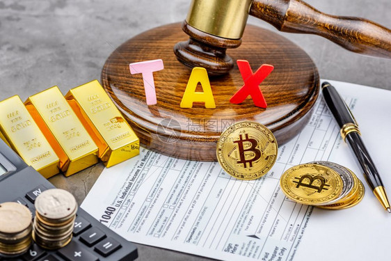 Bitcoin加密货币前方的视图在手架前使用TAX单词计算器和金砖Tax支付概念图片