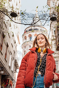土耳其伊斯坦布尔贝奥格鲁美丽迷人快乐的年轻时尚女孩在加拉塔塔上合影身着红色连衣裙的美女坐在伊斯坦布尔的渡船上图片