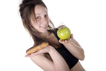在JukCake食品或健康苹果之间选择甜食中的年轻女图片