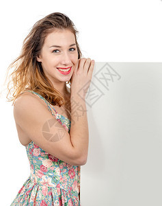快乐笑的年轻女带着复制空间的手签牌图片