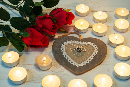 一个浪漫的概念三个红玫瑰心脏和蜡烛图片