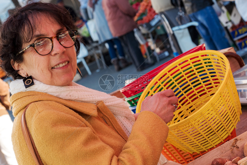 一名妇女在市场上购买蔬菜图片