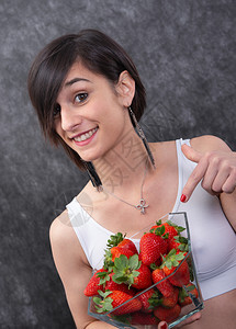 一个漂亮的年轻黑发女人吃草莓图片