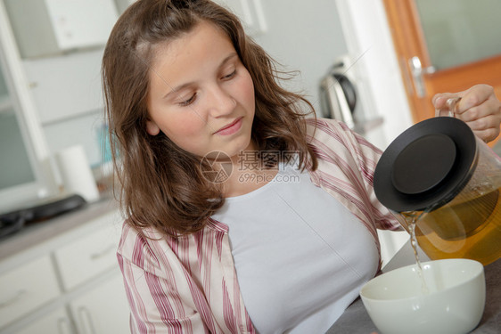 早上十几岁的女孩喝茶在碗里图片