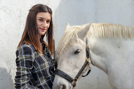 一匹白马的年轻骑手女子肖像图片