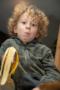 一个金发小男孩吃香蕉图片