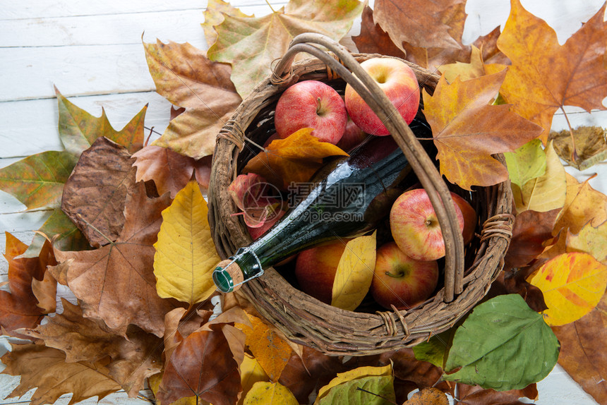 秋天的叶子篮里有一瓶苹果和图片
