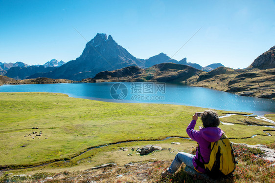 在法国PicOssau拍摄一张照片的妇女远足者图片