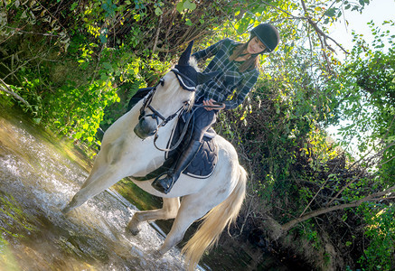 在河里骑马的年轻女子图片