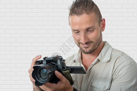 带着Dslr相机的年轻男子微笑摄影师图片