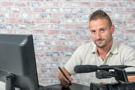 一名男子视频编辑配有图形平板电脑和专业摄像头图片