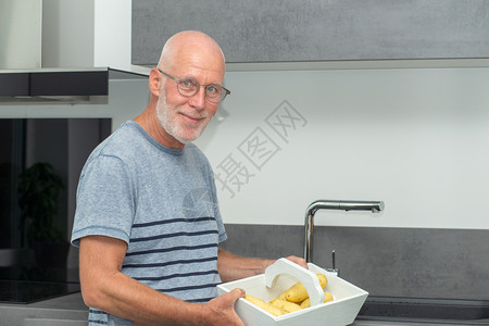在厨房做饭的高级男子图片