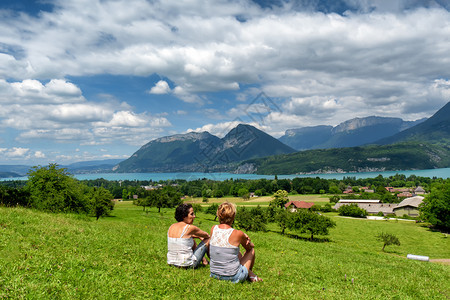 两名妇女看着法国的安妮西湖背景图片