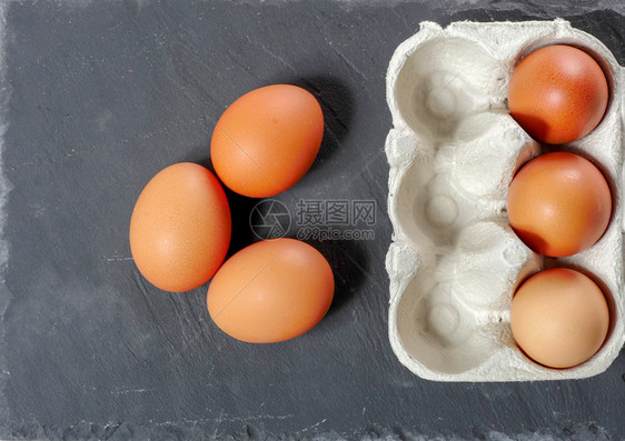 白灰色蛋塔里装着三颗鸡蛋俯视图图片