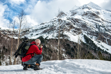 男摄影师在雪山拍照图片