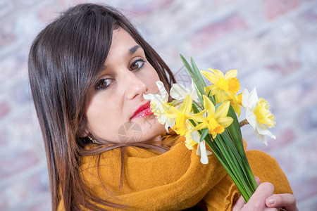 带着一束水仙花的黑发年轻女人图片