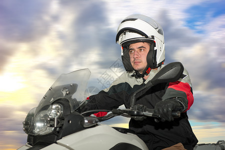 一个年轻人坐在摩托车上头戴盔图片