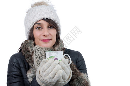 带着冬帽的年轻女子喝杯茶白图片