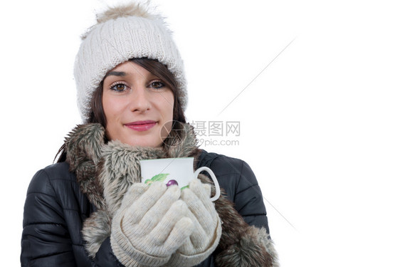 带着冬帽的年轻女子喝杯茶白图片