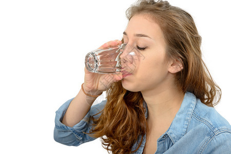 一位年轻女子喝着一杯水孤立在白色背景图片