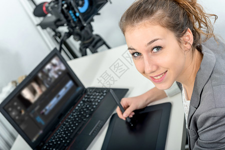 一名年轻女设计师使用图形平板电脑进行视频编辑图片