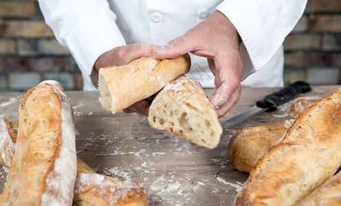 a面包师切割传统的法国面包图片
