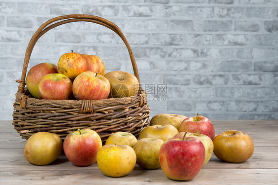 木制桌上一篮子苹果图片