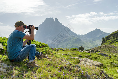 带着照相机和背包拍摄美丽的山峰图片