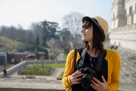 美丽的黑发女拿着相机参观法国城市波比利牛斯图片
