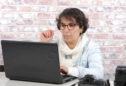 使用笔记本电脑的褐色成年妇女肖像图片