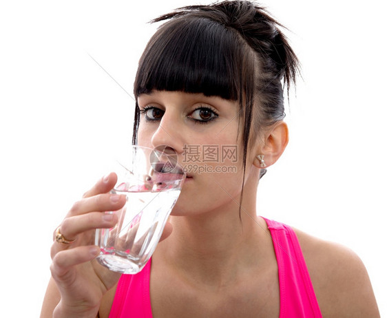 年轻的黑发女孩喝着一杯水孤立在白色背景上图片