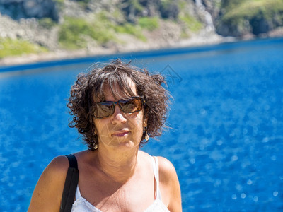 一个戴眼镜的成熟女人肖像山湖背景图片