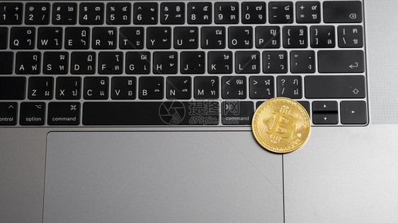 笔记本电脑键盘上的比特币硬图片