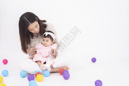 亚裔母亲和可爱的女婴在白背景下快乐图片