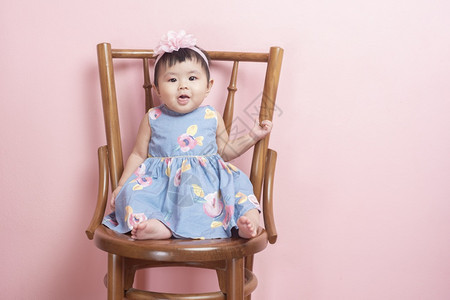 可爱的亚洲女婴是粉红背景的肖像图片