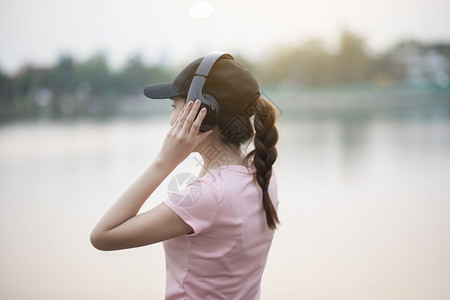 美丽的女人在公园里听音乐图片