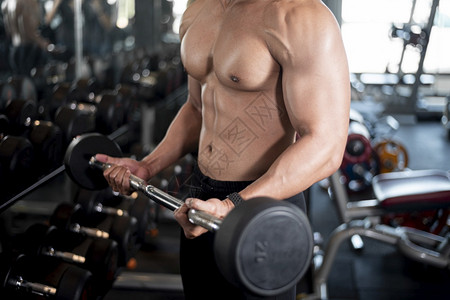 近身肌肉男在健身房锻炼图片