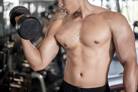 近身肌肉男在健身房锻炼图片