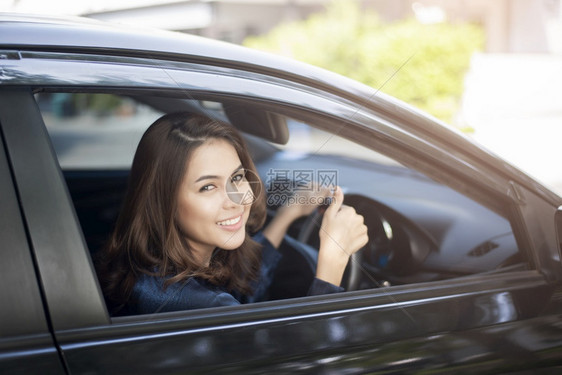 美丽的女士正在驾驶她的车图片