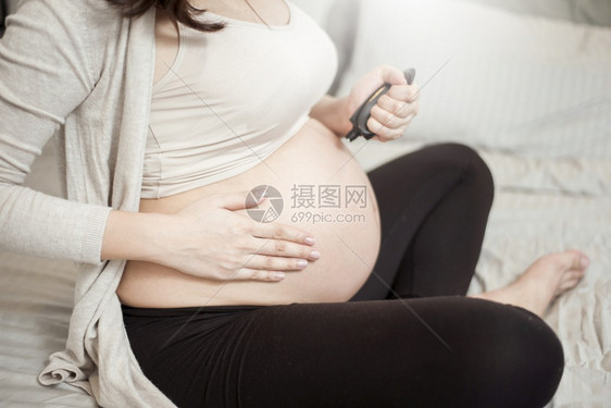 孕妇腹部涂抹乳霜的特写镜头图片