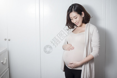 美丽的亚洲孕妇抚摸肚子图片