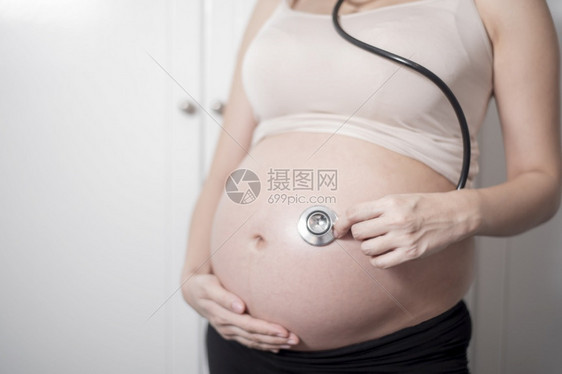 美丽的亚洲孕妇预产期使用听诊器图片
